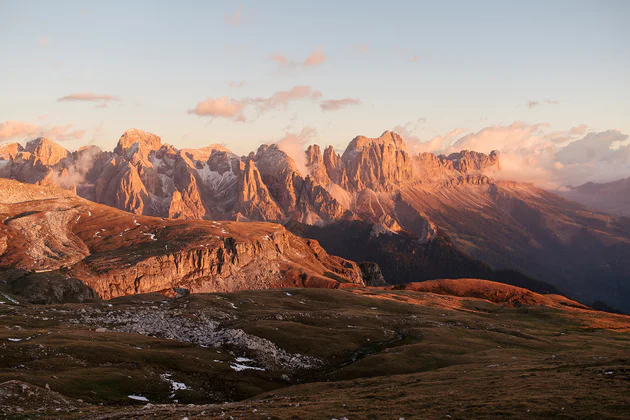 Pohled na Dolomity, které jsou zaplavené rudou září zapadajícího slunce